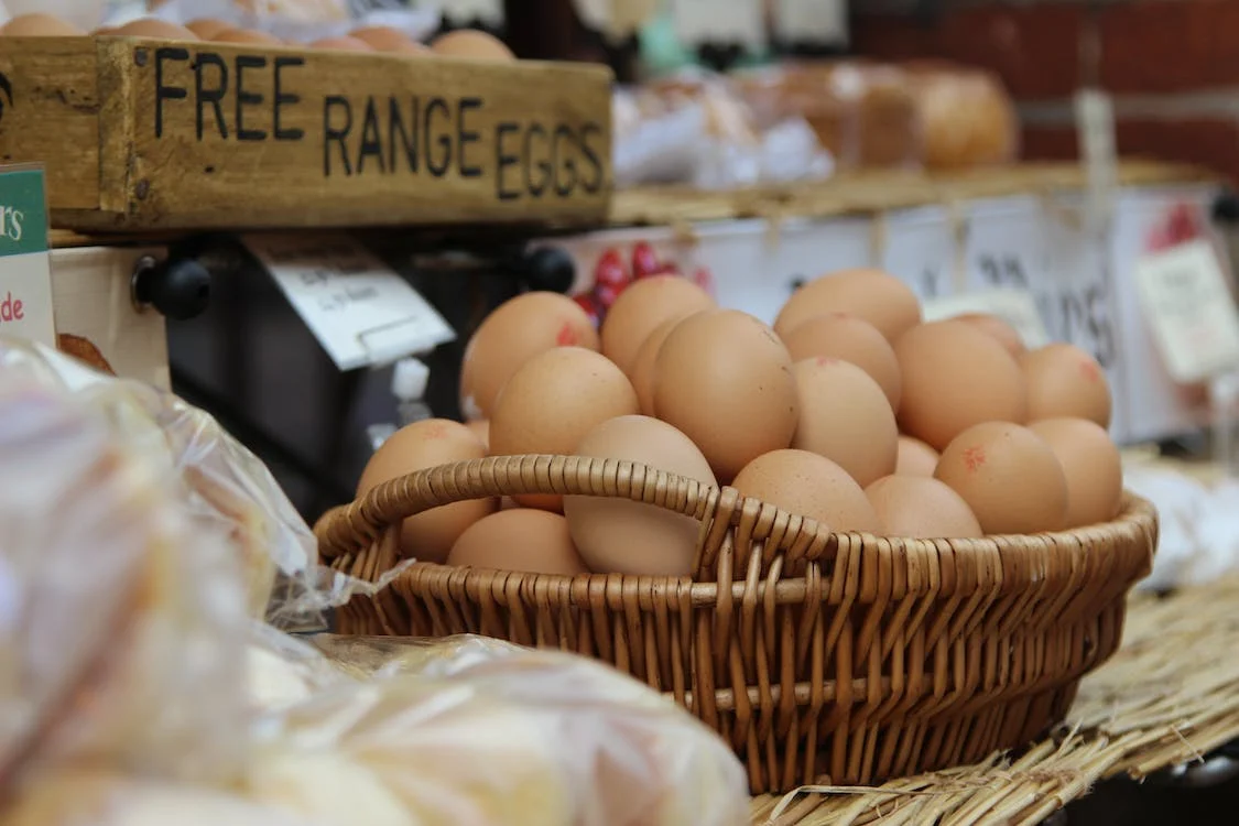 Wicker basket full of brown eggs sign says Free Range Eggs
